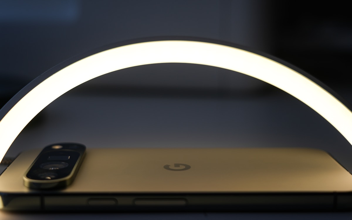 A smartphone lying under the bright arc of a ring light.